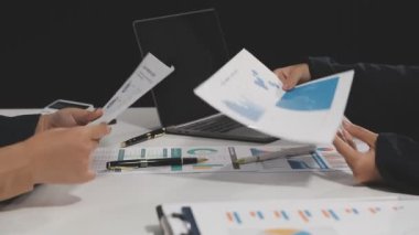 İş adamları masadaki grafikleri ve grafikleri tartışıyor ve analiz ediyorlar.