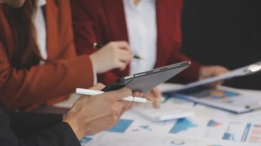 İş adamı ve iş kadını tabletteki mali verileri analiz ediyorlar