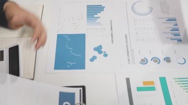 Finansal tablolar ve dizüstü bilgisayarlarla çalışan iş kadını
