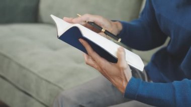 Genç adam kitap okuyor.