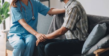 Yaşlılar için Fiziksel Terapi ile Yaraların Hızlandırılması ya da Hastalıklar. Evde tedavi gören kadın bir fizyoterapist vücut kaslarındaki gerginliğe masaj yapar ya da üst düzey bir Asyalı adamla fizik terapide burkulur..