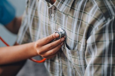 Bayan doktor kalp atışlarını dinliyor.