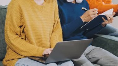 Dizüstü bilgisayarı ve akıllı telefonu olan genç çift odada.