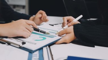 Bir tabletle çalışan ve not defterine yazan bir iş kadını.