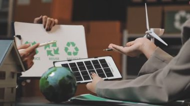 İş adamı tablet kullanıyor ve bir ofiste güneş panelleri tutuyor.