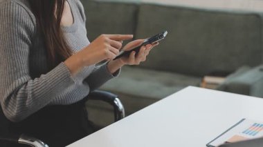 Ofiste akıllı telefon kullanan bir kadın.