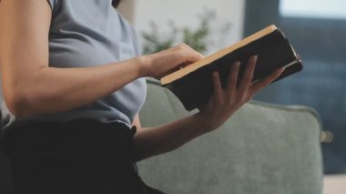 Evde kitap okuyan genç bir kadın.