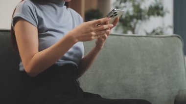 Sabahları akıllı telefon kullanan genç bir kadın.