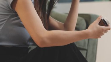 Genç bir kadın akıllı telefon tutuyor ve akıllı telefon kullanıyor.