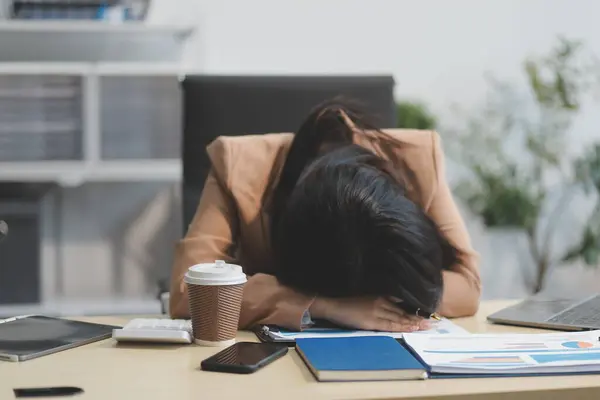 Yorgun ve Asyalı bir kadının portresi ofiste vergi bilgisayarıyla çalışıyor. Üzgün, mutsuz, endişeli, depresyon ya da çalışan hayatı stres konsepti