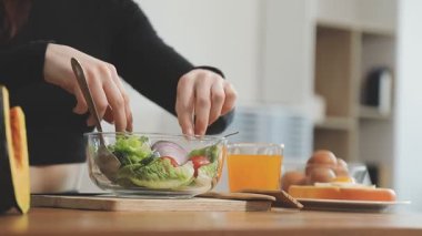 Mutfakta sebze salatası kesen kadın.