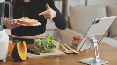 Genç bir kadın blender kullanıyor ve smoothie yapıyor.