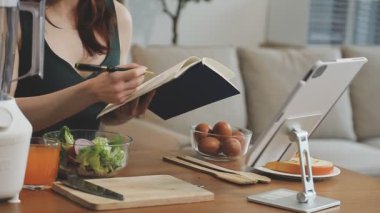 Mutfakta tablet kullanan genç bir kadın.