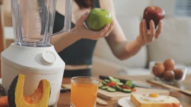 Sağlıklı yemek. Mutfakta blenderi olan genç bir kadın..