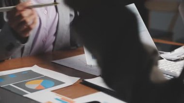 Ofisteki dizüstü bilgisayardaki finansal grafiği analiz eden iş adamı