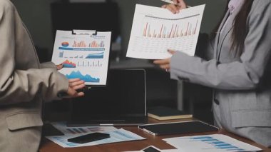 İki işadamı mali verileri analiz ediyor ve bir raporu tartışıyorlar.