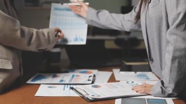 İş adamları modern ofiste mali verileri tartışıyor ve analiz ediyorlar.