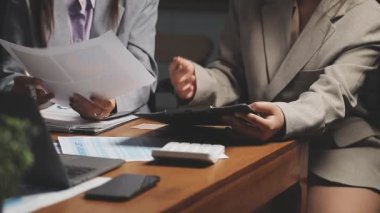 İş kadını ve iş kadını ofiste belgelerle çalışıyorlar.