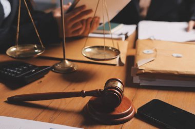 Ofisteki çekici genç avukat iş kadını ve avukatlar ofisdeki ahşap masada pirinç pullu kağıtları tartışıyorlar. Hukuk, hukuk hizmetleri, danışmanlık, Adalet ve emlak kavramı.