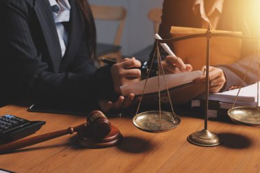 Attractive young lawyer in office Business woman and lawyers discussing contract papers with brass scale on wooden desk in office. Law, legal services, advice, Justice and real estate concept.