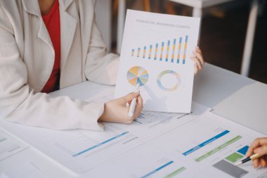 İki genç Asyalı iş kadını ofiste yeni başlatılan proje sunumunda danışmanlık yapıyor ve tartışıyorlar..