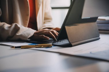 Two young Asian business woman talk, consult, discuss working with new startup project idea presentation analyze plan marketing and investment in the office.