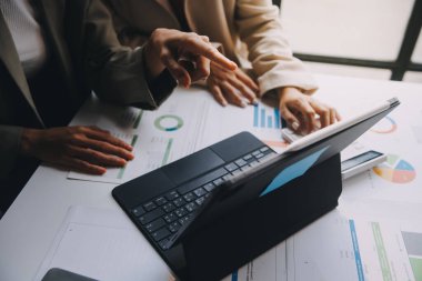 Asyalı iş adamlarından oluşan bir grup modern ofiste toplanıyor tasarım planlama ve fikir kavramı üzerinde çalışıyorlar.