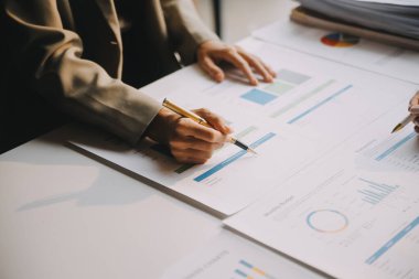 İki genç Asyalı iş kadını ofiste yeni başlatılan proje sunumunda danışmanlık yapıyor ve tartışıyorlar..