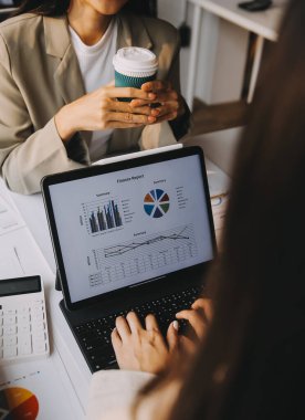 Two young Asian business woman talk, consult, discuss working with new startup project idea presentation analyze plan marketing and investment in the office.