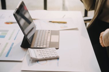 Asyalı iş adamlarından oluşan bir grup modern ofiste toplanıyor tasarım planlama ve fikir kavramı üzerinde çalışıyorlar.