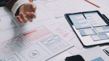 Taslak ve çizimlerle tablet kullanan tasarımcı