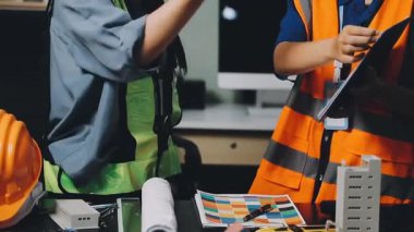 Fabrikada çalışan üniformalı ve kasklı genç Asyalı mühendis.