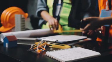 İnşaat projesiyle çalışan mühendis veya mühendis veya mühendis ve mühendislik konsepti için ofis inşaatı alanının planı ve planı üzerinde çalışıyor..