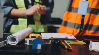 Koruyucu üniformalı ve kasklı işçileri ofiste mezurayla yakın çekim yapın. inşaat kavramı.