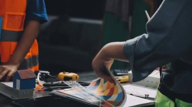 Atölyede çalışan genç bir adam, dizüstü bilgisayarla çalışıyor..