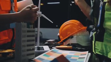 Modern bir ofiste koruyucu miğferli ve çelik yelekli bir inşaat mühendisi..