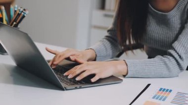 İş kadını dizüstü bilgisayar kullanıyor ve ofiste çalışıyor.