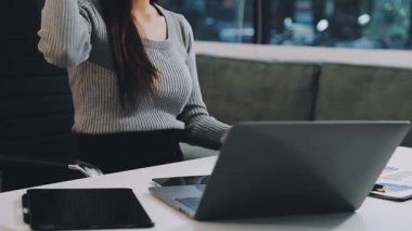 Ofiste bir dizüstü bilgisayar üzerinde çalışan kadın