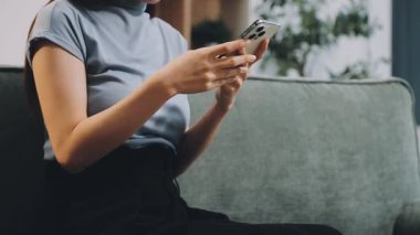 Oturma odasında cep telefonu kullanan kadın.