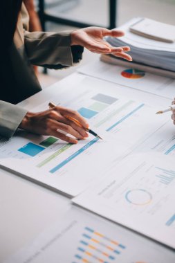 İki genç Asyalı iş kadını ofiste yeni başlatılan proje sunumunda danışmanlık yapıyor ve tartışıyorlar..