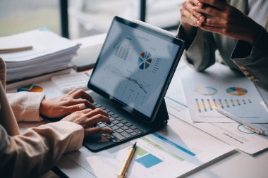 Two young Asian business woman talk, consult, discuss working with new startup project idea presentation analyze plan marketing and investment in the office.