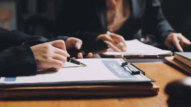 Ofisteki ahşap masada çalışan iş kadınlarının elleri.