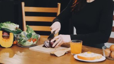 Genç ve güzel bir kadın mutfakta salata yapıyor.