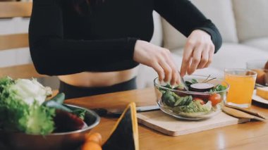Genç kadın evde sağlıklı yemek yapıyor.