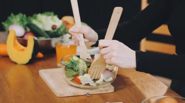 Kadın evdeki mutfakta salata hazırlıyor..