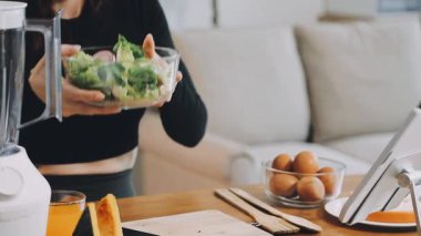 Genç kadın mutfakta sağlıklı yemek yapıyor.