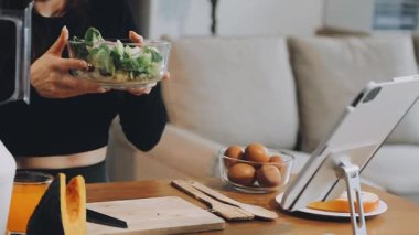 Genç bir kadın mutfakta sağlıklı kahvaltı hazırlıyor.