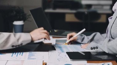 İş adamları dizüstü bilgisayarda çalışıyor ve grafikleri analiz ediyor.