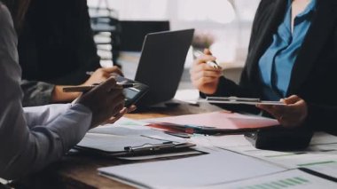 İşadamları mali belgeleri ve ofiste fikirleri tartışıyor