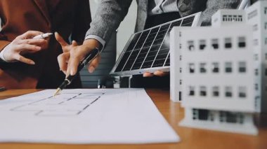 Genç mimar mühendisi yeni bir plan üzerinde çalışıyor ve yeni projeyi tartışıyor.